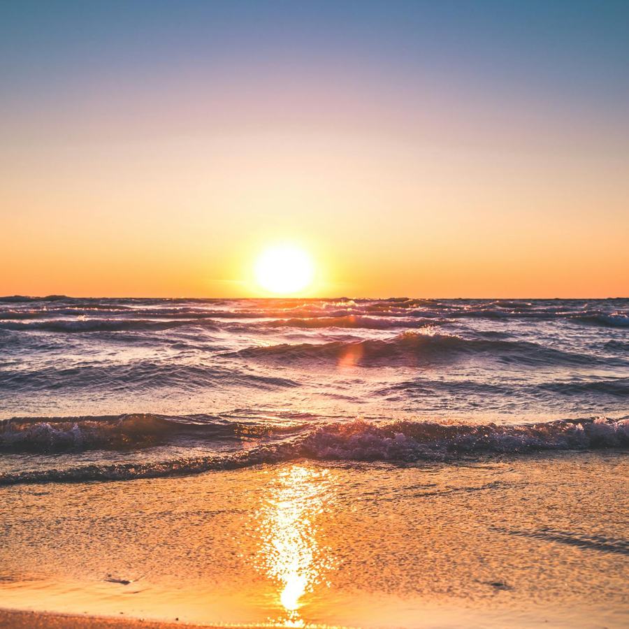Turquoise sea along a quiet undeveloped shoreline under clear sky