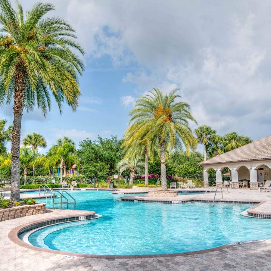 Resort swimming pool with lounge chairs and clear blue water