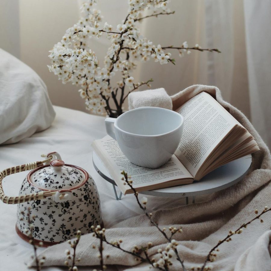 Elegant in-room tea service with teapot and cup arranged on a hotel bed