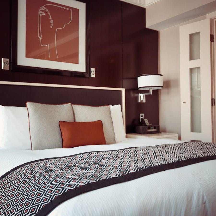 Comfortable hotel bed with white bedding and plush pillows ready for guests