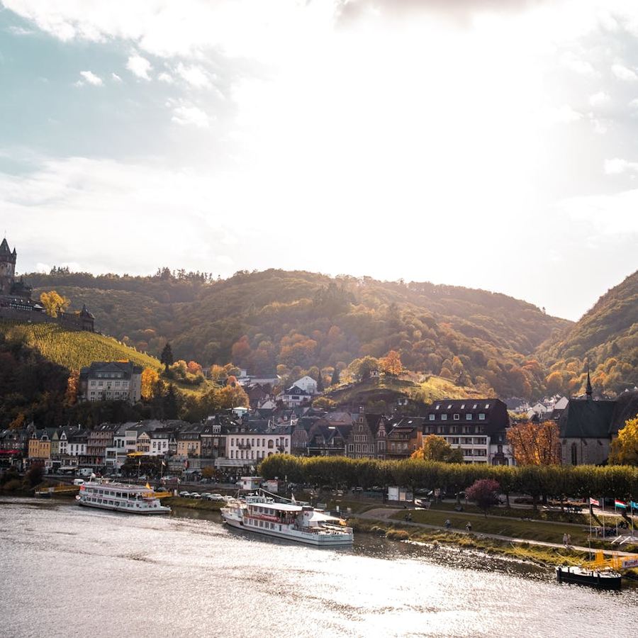 Picturesque riverside town with historic buildings and green hills along the water