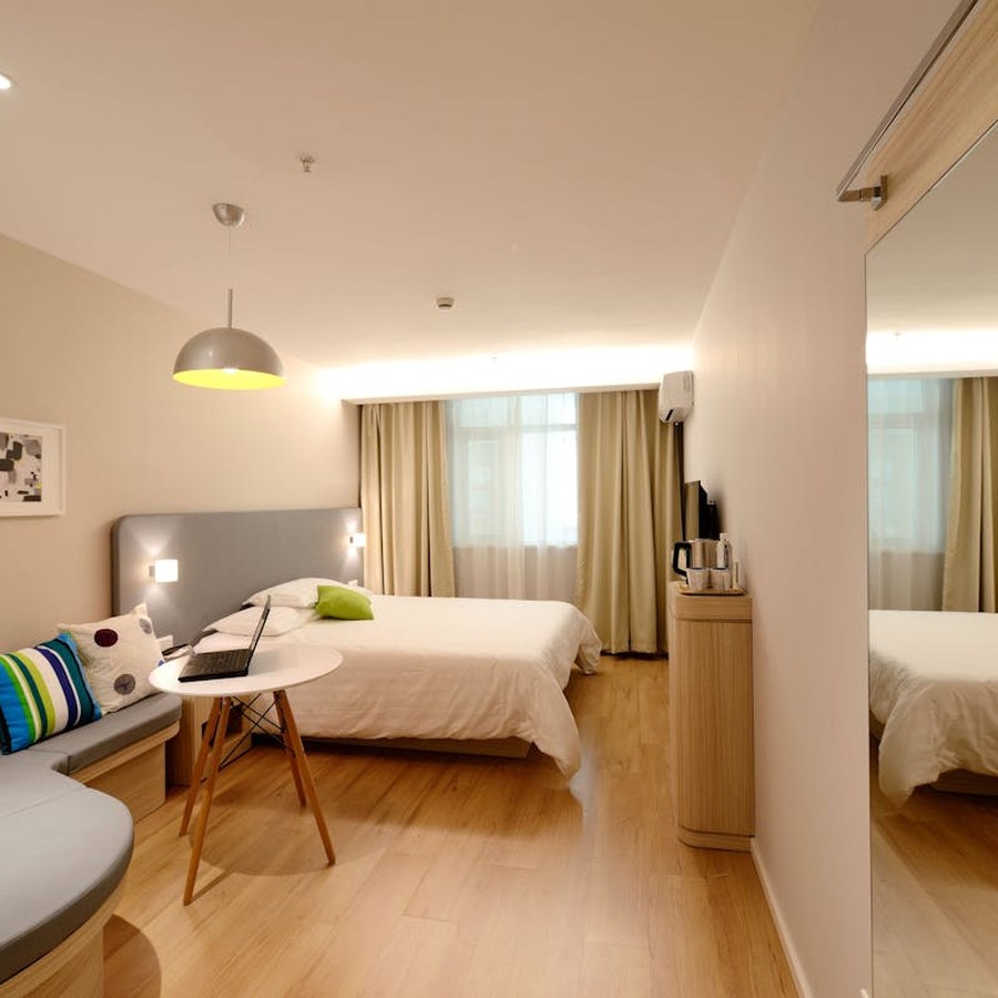 Calm hotel bedroom with white linens and soft natural light